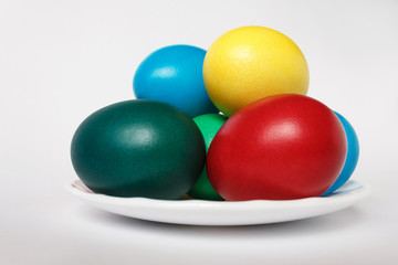 Colored easter eggs in white plate on a background. Isolate. White background.
