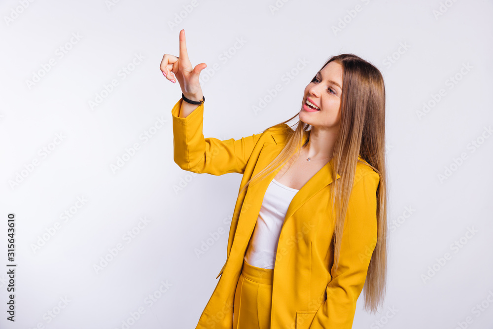 Wall mural portrait of young woman in yellow trouser suit on the light back