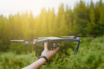 A man catching drone with his hand.Photographer controls a quadcopter drone to take aerial view...