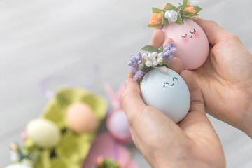 woman makes cute decorative eggs for easter holiday. do-it-yourself easter gifts concept. cute pastel colored eggs - obrazy, fototapety, plakaty