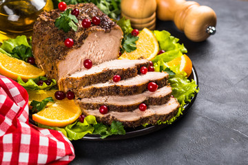 Baked pork meat with cranberry and oranges.