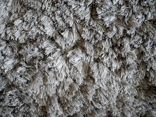 Grey furry carpet texture top view.