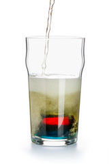 Depth charge cocktail of beer, blue Curacao liqueur, grenadine and vodka, prepared by mixing a submerged inverted Cup at the bottom of a beer glass. Start of the glass filling process.