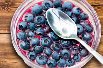 Jelly with blueberry, in a bowl on wooden background.