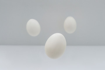 Fototapeta na wymiar Flying easter white eggs on white background.