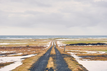 Dirt road to nowhere in icelandic landscape. Path to ocean. Snaefellsnes peninsula (region of...