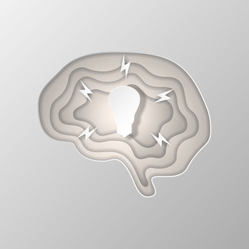 Gray silhouette of the brain carved on paper.