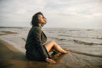 Woman portrait in  coat on sea beach 