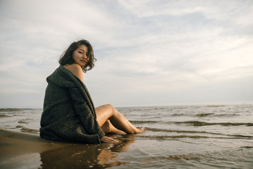 Fototapeta na wymiar Woman portrait in coat on sea beach 