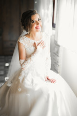 Naklejka premium Gorgeous bride in robe posing and preparing for the wedding ceremony face in a room