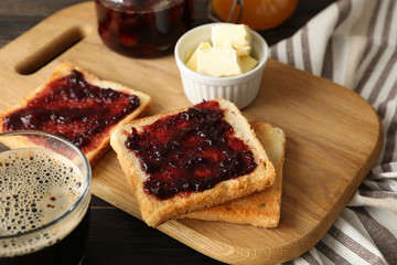 Composition with delicious toasts with jam on wood board, close up