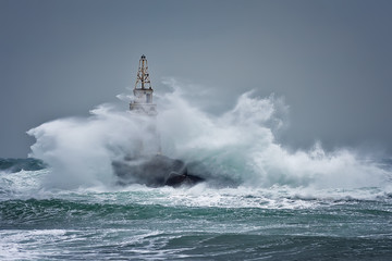 Naklejka premium Lighthouse In Stormy Landscape. Storm waves over the Lighthouse -Ahtopol, Black Sea, Bulgaria.