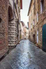 Amazing view with a narrow picturesque medieval street of old town of Montepulciano in Tuscany, Italy