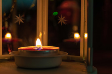 Candle in a lamp close-up with copy space on a dark background with bokeh. Focus with shallow depth of field.