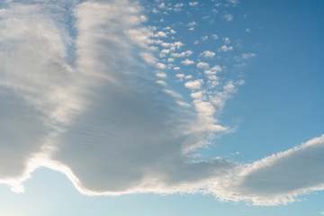 Beautiful cirrus and cumulus clouds on a bright blue sky. Colorful positive natural landscape
