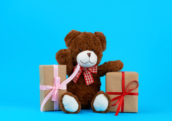 brown cute teddy bear and gifts wrapped in brown eco kraft paper and tied with a ribbon
