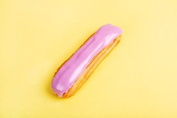 Eclairs, macarons, blackberries and blueberries on dark concrete background.