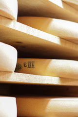 Comté cheese refining cellar on traditional spruce wooden shelves, closeup