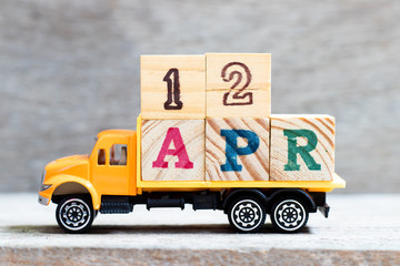 Truck hold letter block in word 12apr on wood background (Concept for date 12 month April)