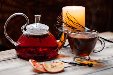 Composition with natural healthy organic herbal rooibos tea in glass teapot and cup. Wooden...