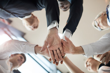 Close-up of business people standing in circle and holding hands they supporting each other during team work