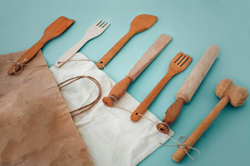 Wooden kitchen utensils: hammer, rolling pin, fork, spatula and eco paper bag