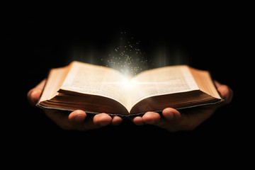 Man holds holy bible book on black background. - 315658817