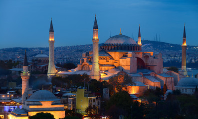 Lights on Hagia Sophia and Firuz Aga Mosque at dusk in Istanbul Turkey