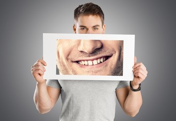 Man holding poster with smile on grey background