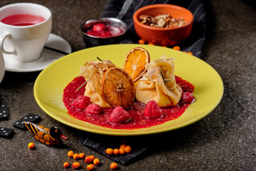Crepes With Berries. pancakes with fresh berries, raspberries, strawberry, seabuckthorn and orange. Yummy pancake on the table, top view. Russian kitchen