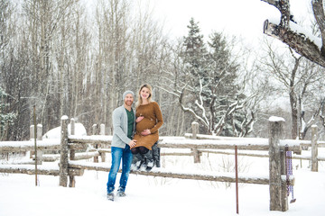 A Pregnant couple together in winter nature