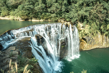 Fototapeta na wymiar Shihfen Waterfall, Fifteen meters tall and 30 meters wide, It is the largest curtain-type waterfall in Taiwan