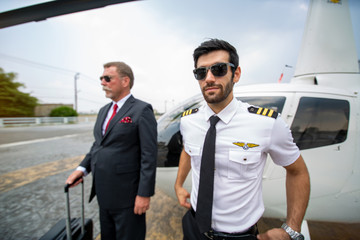 Confident Helicopter pilot and businessman walking from the vehicle at Airport terminal © FotoArtist