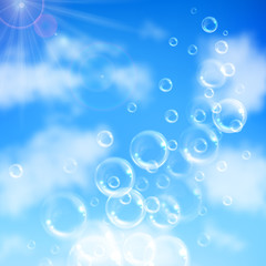 Realistic transparent floating soap bubbles on blue sky background. Design element for advertising booklet, flyer or poster