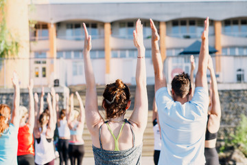 Fototapeta premium A big group of people attending yoga classes on a pontoon near the lake.
