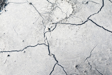 Obraz premium The structure of the earth's surface cracks, soil on a white background, desert cracks, arid surfaces in the dry ground, with many fissures and scratches