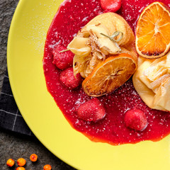 Crepes With Berries. pancakes with fresh berries, raspberries, strawberry, seabuckthorn and orange. Yummy pancake on the table, top view. Russian kitchen