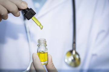  Doctors  holding bottle of Cannabis oil in pipette,hemp product, CBD cannabis OIL.  medical marijuana concept.