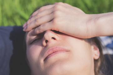 Tired woman holds palm on her head to relieve pain