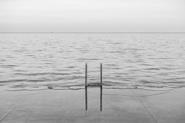 Black and White Photo of a Ladder with a Reflection on the Lakefront Trail along Lake Michigan in Chicago