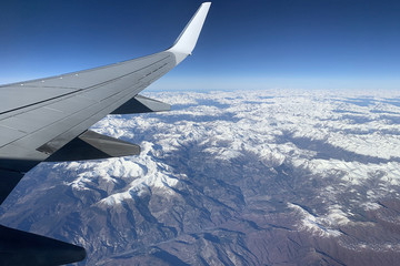 Obraz premium view of snowy mountains from the porthole of an airplane