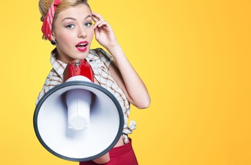 Fototapeta premium Portrait of woman holding megaphone, dressed in pin-up style