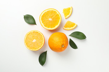 Oranges and leaves on white background, top view