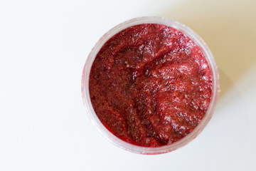 red body scrub made from natural salt. a jar of cosmetics on a white background. body care. SPA at home and in the beauty salon. The concept of female beauty and body care. against cellulite. 