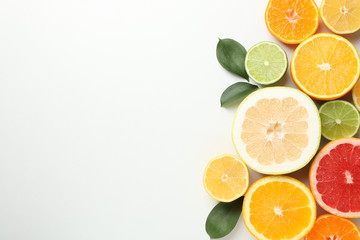 Citrus fruits and leaves on white background, space for text