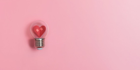 Red heart in light bulb on pink background with copy space. Valentine's day, Creative idea,...