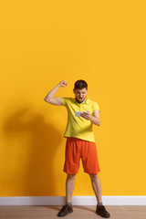 Cheering, celebrating win. Young caucasian man using smartphone, serfing, chatting, betting. Full length portrait isolated on yellow background. Concept of modern technologies, millennials, social