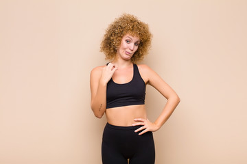 young afro woman looking arrogant, successful, positive and proud, pointing to self sport concept