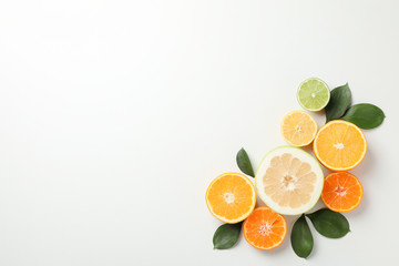 Citrus fruits and leaves on white background, space for text