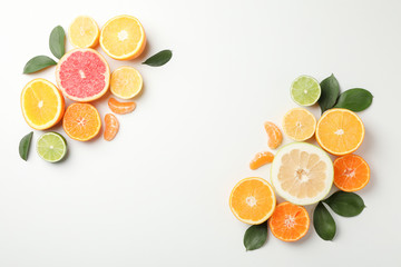 Citrus fruits and leaves on white background, space for text